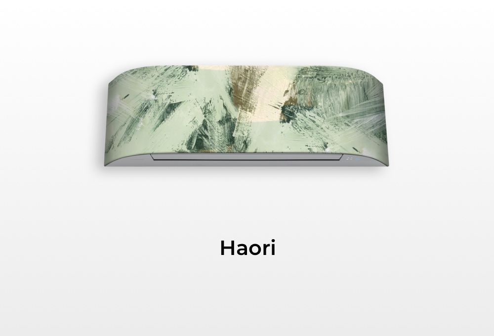 Climatizzatore Toshiba Haori con cover personalizzata astratta nei toni del verde e beige, montato su sfondo neutro con scritta “Haori” sottostante.